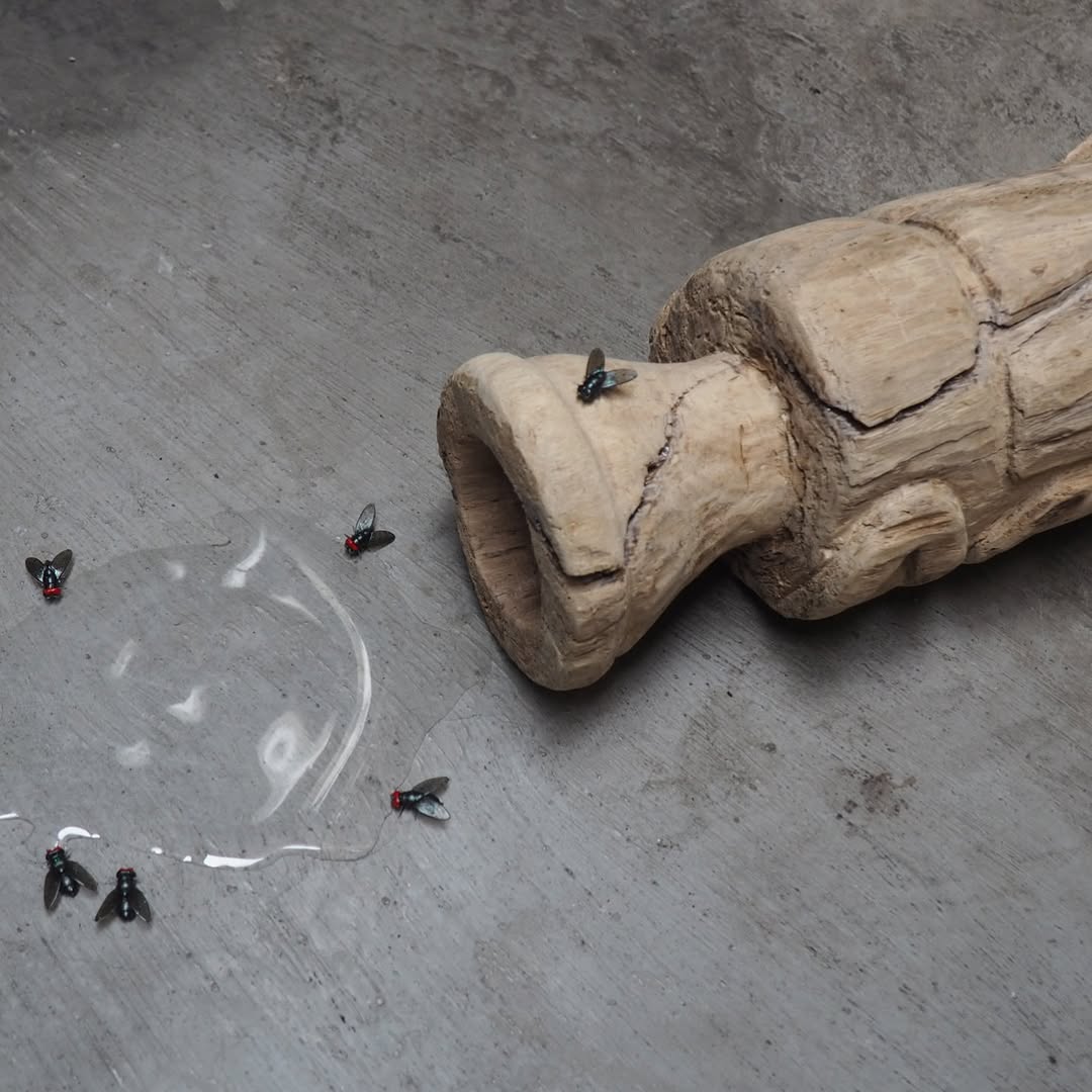 Fly Vessel — carved wood sculpture with rubber flies on concrete floor