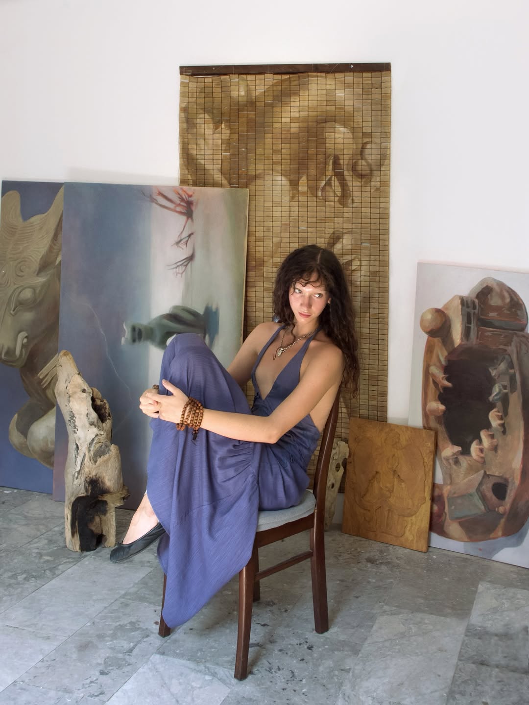 Yasy Bachurina in her studio, holding a carved wooden object